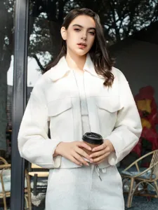 Close-up details of the casual white textured short jacket with lapel and zip design.