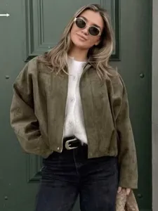 Vue détaillée d'une veste bomber en daim vert olive pour femme avec haut blanc et jean.