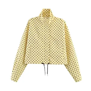 Chaqueta de manga larga con lunares negros detalle del cuello alto y estampado.
