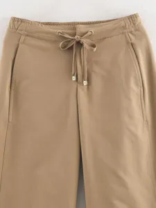 Casual khaki wide leg trousers waist detail featuring adjustable drawstring and metal tips.