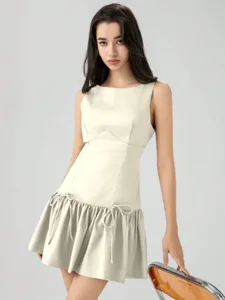 Sleeveless mini dress detail showcasing cute side bows and elegant drop waist ruffle hem.
