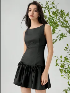 Detail view of the black sleeveless mini dress with bow decorations and elegant ruched skirt.