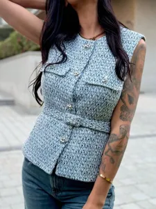 Detailed shot of a blue textured tweed sleeveless vest featuring ornate metal buttons and waist belt.