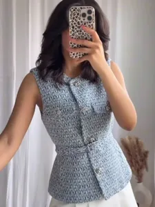 Detailed view of women's tweed sleeveless vest with chic metal buttons and matching belt.