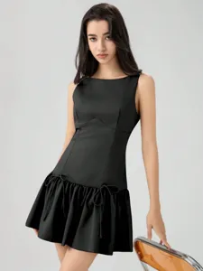 Details of black sleeveless mini dress featuring drop-waist bow ties and elegant ruffle skirt.