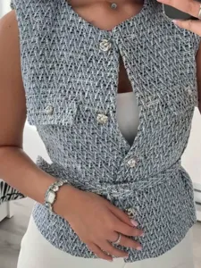 Detail view of women's tweed vest with metal buttons and belt, textured crew neck style.