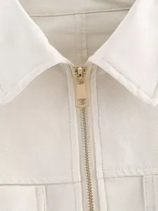 Detailed shot of a stylish white lapel zip-up top collar and gold zipper for womens wear.