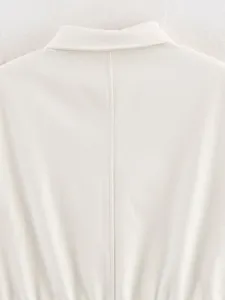 Detail view of the stylish off-white collared top back, showing neat stitching and fabric.
