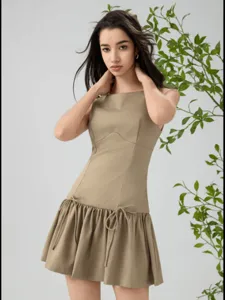 Detailed view of a stylish khaki sleeveless mini dress featuring cute bow ties and resort aesthetic.