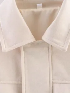 Vue détaillée du col et de la patte de la veste à revers texturée polaire beige.