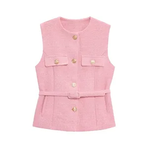 Pink tweed vest detail featuring elegant gold buttons, chic chest pockets and a stylish belt.