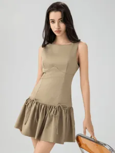 Chic sleeveless mini dress in khaki with dropped waist, ruched skirt, and cute bow tie details.