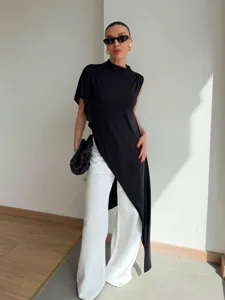 Asymmetrical high neck sleeveless top paired with white trousers for a chic summer fashion look.