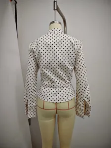 Back view detail of women long sleeve white shirt with black polka dots and waist belt.