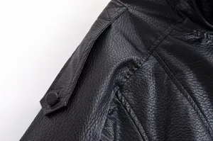 Gros plan détaillé sur l'épaule d'une veste en similicuir noir à texture litchi.