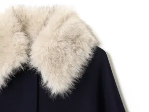 Close-up of women's warm winter wool coat with luxury faux fur collar, stylish detail.