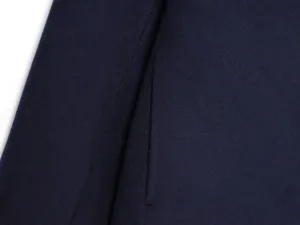 Navy blue wool coat fabric detail close up showcasing pocket seam and fine texture.