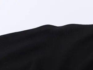 Close-up view of black ribbed fabric texture, showcasing fine knit clothing edge details.