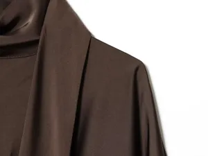 Close-up view of the elegant brown satin scarf collar and shoulder detail on a short dress.