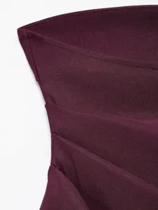 Close-up detail of burgundy strapless top featuring stylish asymmetrical diagonal pleats.
