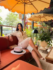 Detail view of the fashion polka dot long sleeve shirt and pants set in cafe backdrop.