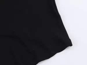 Detailed view of the black sleeveless top fabric, showing fine texture and neat stitching.