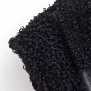 Λεπτομέλεια υφής μαύρου συνθετικού fleece με χνουδωτό σγουρό ύφασμα και δερμάτινη επένδυση.