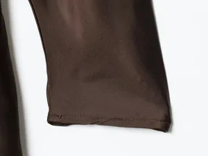 Close up view of dark brown satin dress sleeve cuff showcasing fine stitching detail.