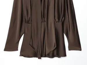 Close-up of dark brown satin blouse featuring an elegant scarf collar and long sleeves.