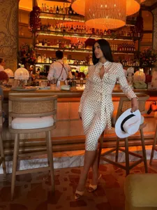Detail view of the stylish polka dot long sleeve shirt and pants set worn in a luxury bar.