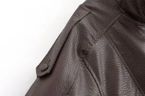 Gros plan sur les détails d'épaule et de couture d'une veste en cuir marron texturé.