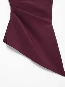 Close-up detail of dark burgundy asymmetric pleated strapless top showing stylish fashion.