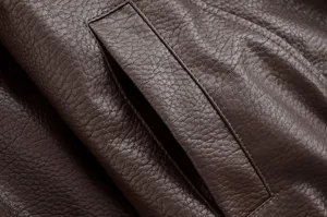 Detail de veste en cuir synthetique marron, texture grain litchi, vetement mode femme.