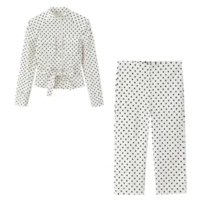 Details of the stylish women white and black polka dot long sleeve blouse and trousers set.