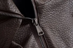 Gros plan détaillé de la veste en cuir grain litchi marron avec fermeture éclair.