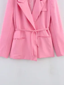 Détail de veste blazer rose mettant en valeur le revers, la ceinture et les poches.
