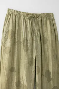Gros plan détail du pantalon décontracté vert olive pour femme avec taille élastique et motif.