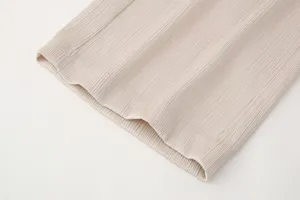Vista detallada de tela plisada con textura vertical fina para prendas de primavera de mujer.