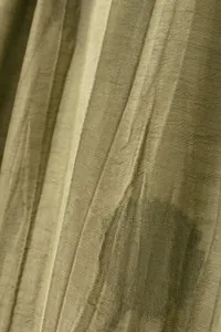Gros plan de la texture du tissu jacquard vert olive avec un motif subtil et un beau tombé.