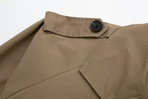 Close-up detail of women casual khaki trench coat lapel button and fine fabric texture.