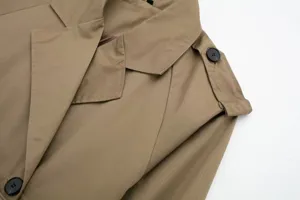 Detail view of khaki women casual trench coat jacket lapel shoulder button fabric.