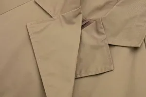 Close-up shot of the elegant khaki trench coat lapel showing exquisite stitching details.