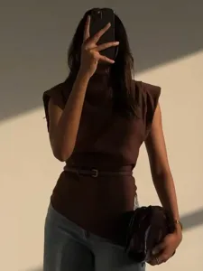Brown sleeveless shoulder-padded top with belt, stylish women's apparel for spring mode.