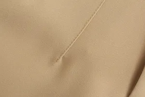Detailed view of women's khaki suit pants fabric, showing fine texture and neat stitching.