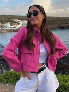 Vista detallada de una elegante chaqueta camisa de tweed rosa al aire libre, textura y corte.