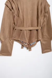Close up view of women faux suede jacket detail, belted waist and unique hem design.