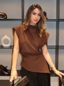 Chic brown women's top featuring structured shoulder pads and a trendy asymmetrical hem.