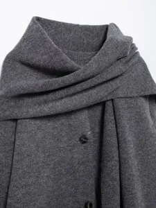 Close-up detail of gray knitted short coat with elegant wrap scarf collar and dark buttons.