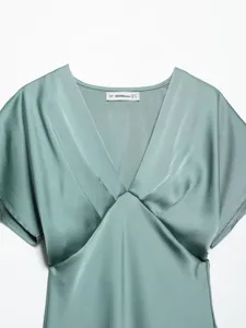 Detailed view of women's elegant V-neck satin dress collar, soft fabric texture and short sleeves.