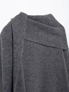 Close-up detail of dark gray knitted coat with scarf collar, premium wool blend fabric.